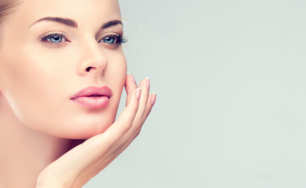 A beautiful woman wearing makeup and touching her face